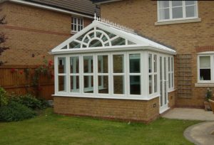 White gable fronted conservatory with brick dwarf wall and french doors