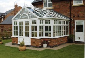 gable fronted conservatory with brick dwarf wall and potted plants